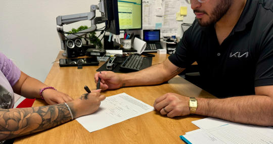 Woman Signing for New Car Deal