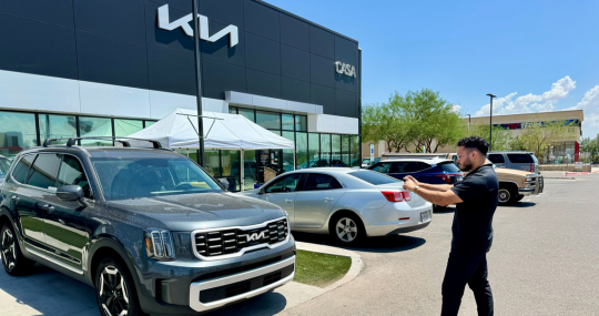 Man Taking Pictures of Trade-In Vehicle at Casa Kia for Offer