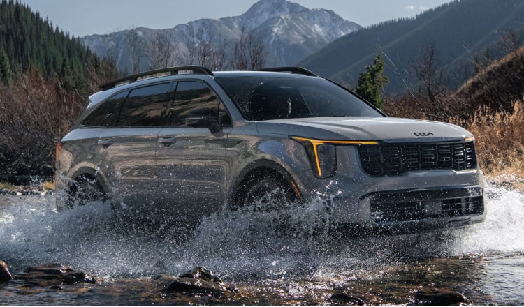 Kia SUV driving thru a river